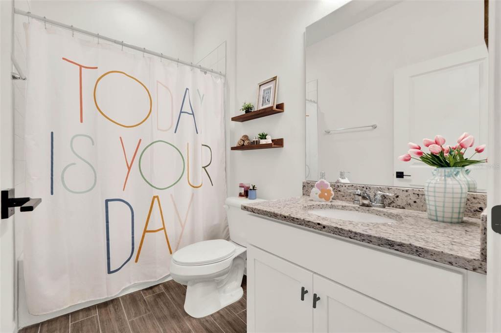 533 Avila Place Howey-in-the-Hills, FL 34737 - Photo 25 of 42 a bathroom with a granite countertop toilet sink and mirror