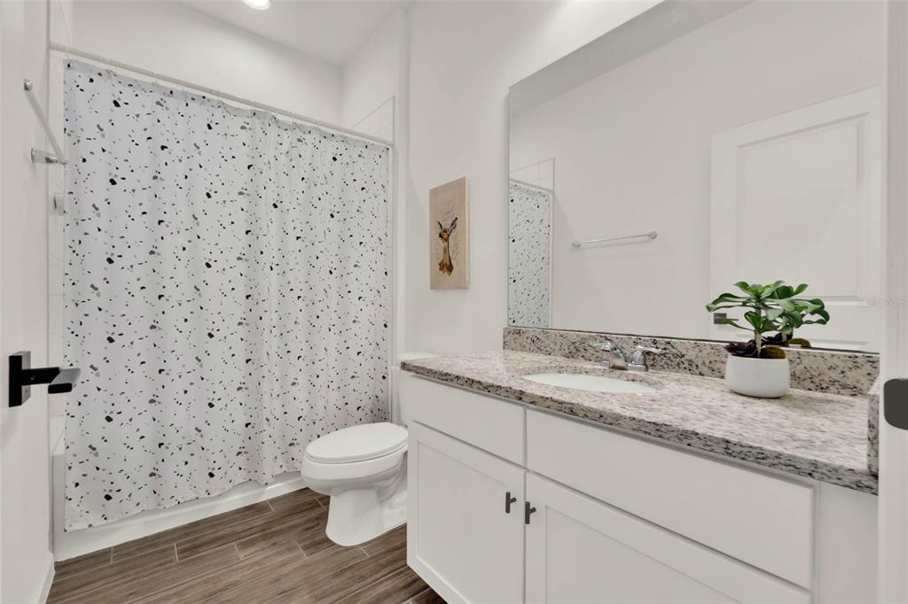 533 Avila Place Howey-in-the-Hills, FL 34737 - Photo 26 of 42 a bathroom with a granite countertop sink a toilet and a shower