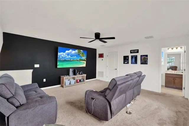 a living room with furniture and a ceiling fan
