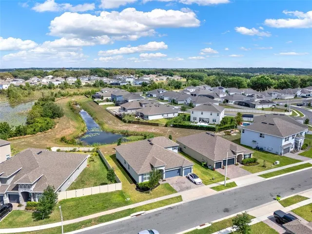 an aerial view of residential houses with outdoor space and ocean view