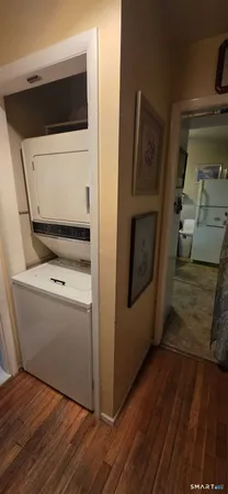 a utility room with wooden floor washer and dryer