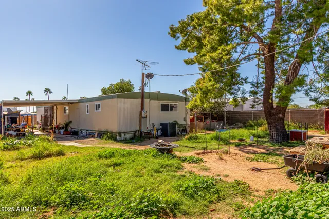 a view of backyard with a table and chairs under an umbrella