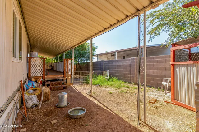 a view of a patio with table and chairs and wooden fence