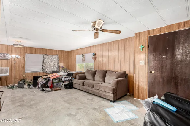 a living room with furniture ceiling fan and a window