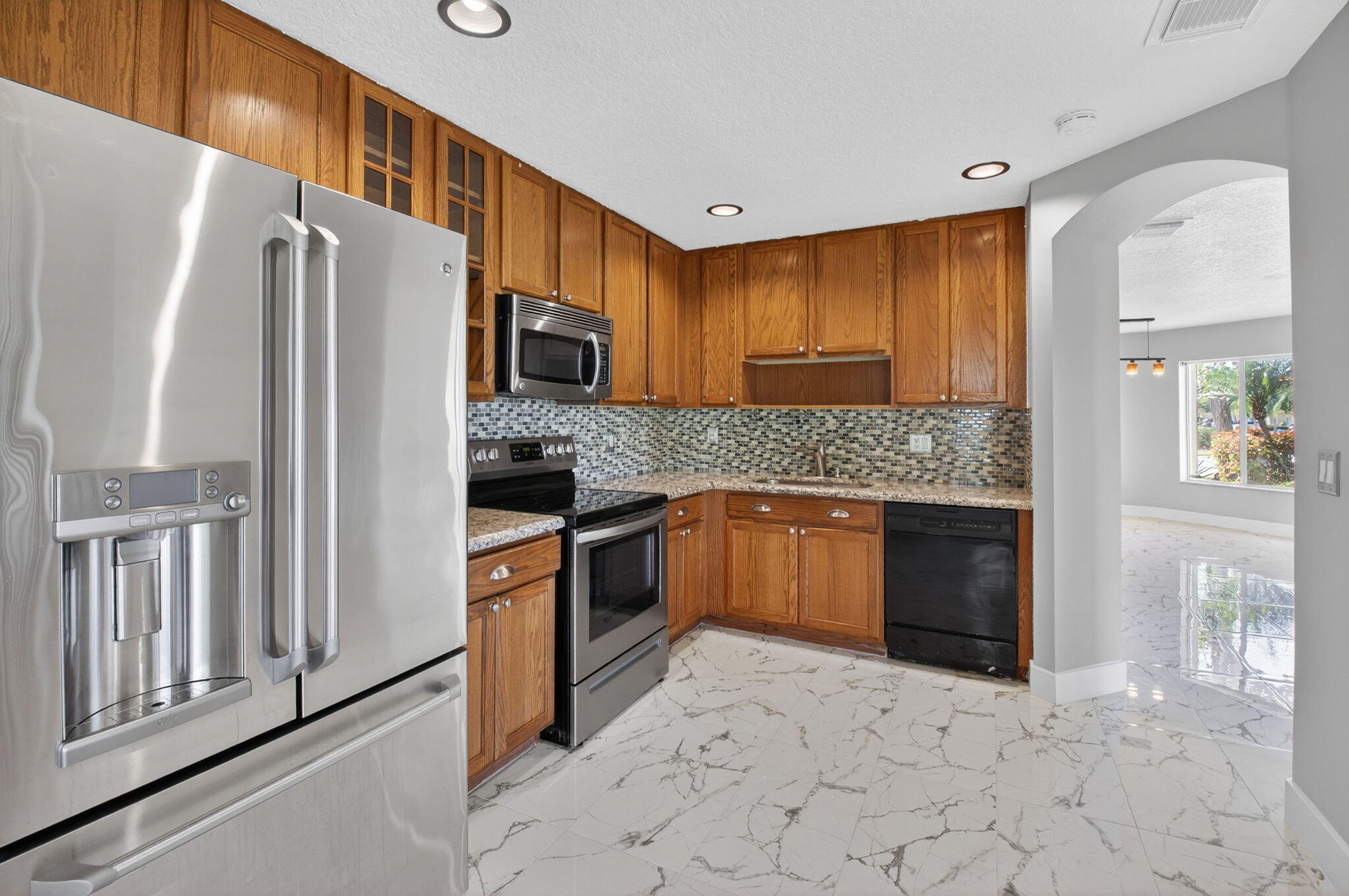1728 Arezzo Circle Boynton Beach, FL 33436 - Photo 17 of 66 a kitchen with stainless steel appliances granite countertop a refrigerator and a stove top oven