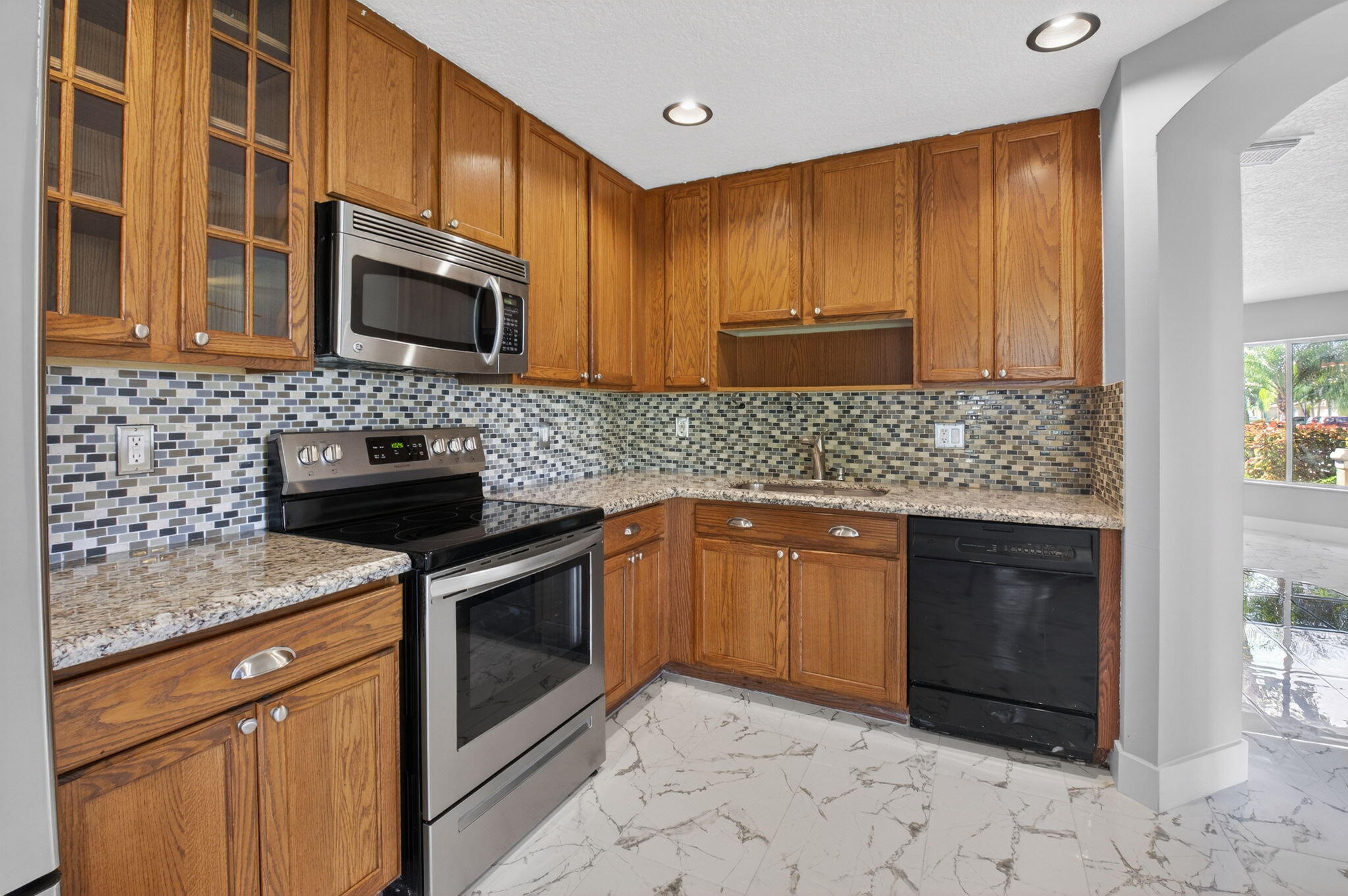 1728 Arezzo Circle Boynton Beach, FL 33436 - Photo 18 of 66 a kitchen with stainless steel appliances granite countertop a sink stove and microwave