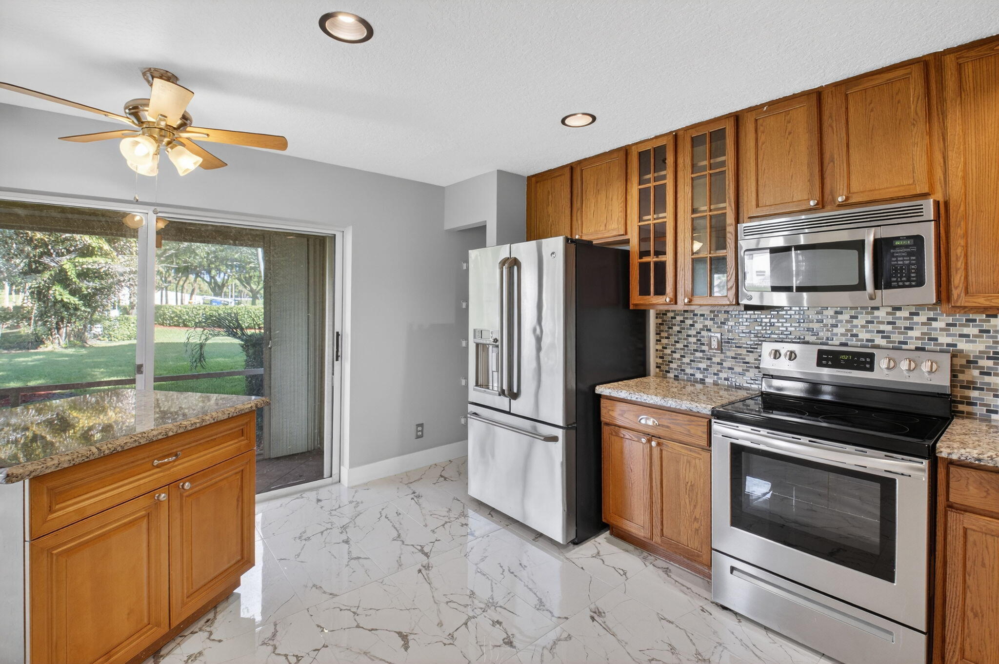 1728 Arezzo Circle Boynton Beach, FL 33436 - Photo 20 of 66 a kitchen with stainless steel appliances granite countertop a stove a refrigerator and a microwave