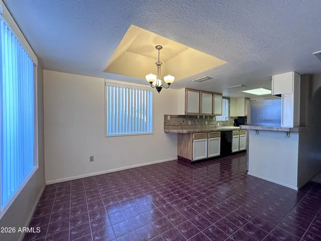 a view of a kitchen with a sink and dishwasher a refrigerator with wooden floor