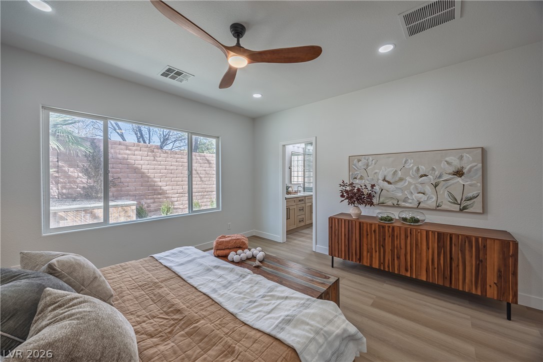 10982 Village Ridge Lane Las Vegas, NV 89135 - Photo 9 of 12 A naturally illuminated bedroom features light wood-look flooring and a contemporary ceiling fan.