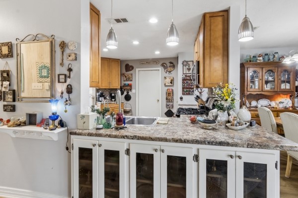 9211 Benwick Street Spring, TX 77379 - Photo 13 of 24 Pendulum and can lighting are just some of the upgrades in the kitchen.