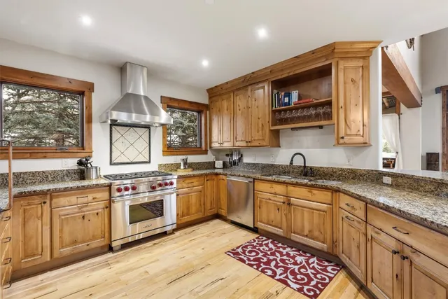 a kitchen with stainless steel appliances granite countertop a stove sink and cabinets