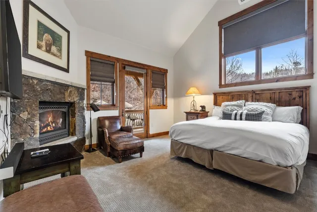 a spacious bedroom with a bed a couch and large window