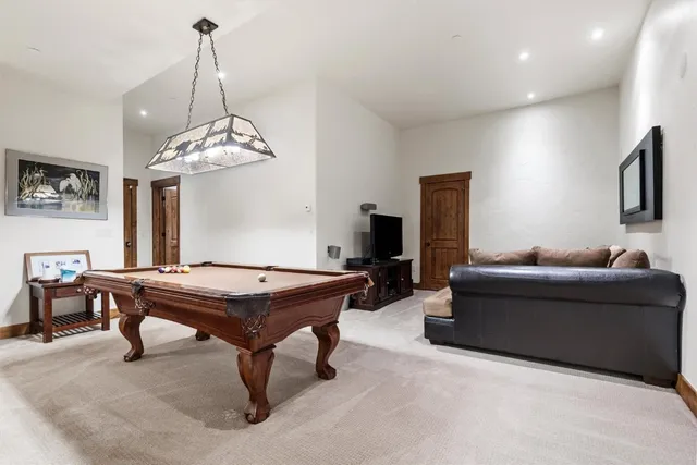 a living room with furniture a chandelier and a flat screen tv