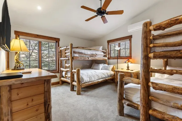 a bedroom with a bed and large windows