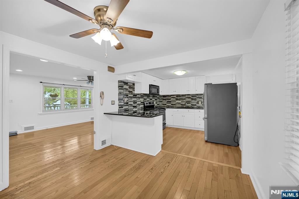 3 Country Club Road Livingston, NJ 07039 - Photo 11 of 37 a kitchen with stainless steel appliances kitchen island granite countertop a refrigerator a stove and white cabinets with wooden floor