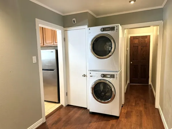 a utility room with wooden floor washer and dryer