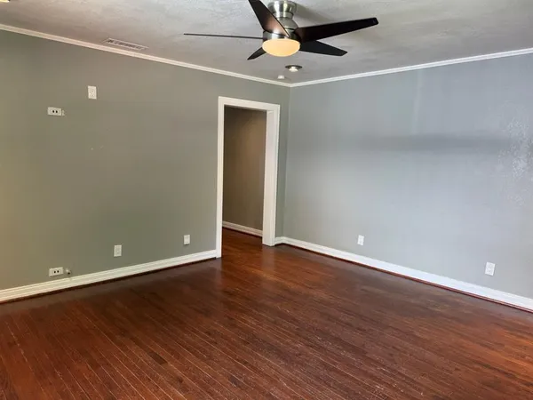 a view of an empty room with wooden floor