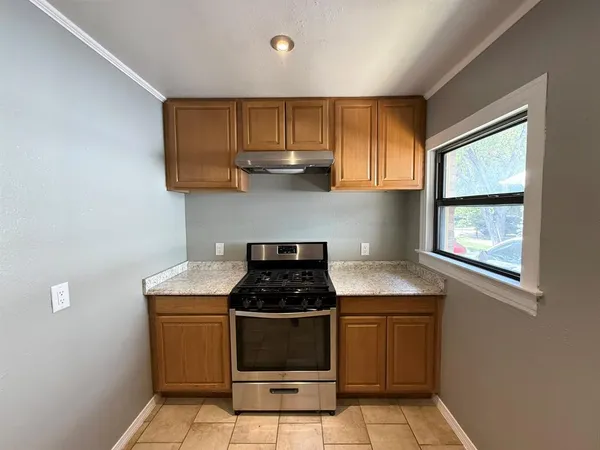 a kitchen with stainless steel appliances granite countertop a stove a sink and a microwave