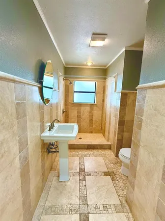 a bathroom with a sink a toilet and shower