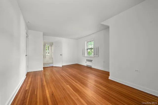 a view of a room with wooden floor and window