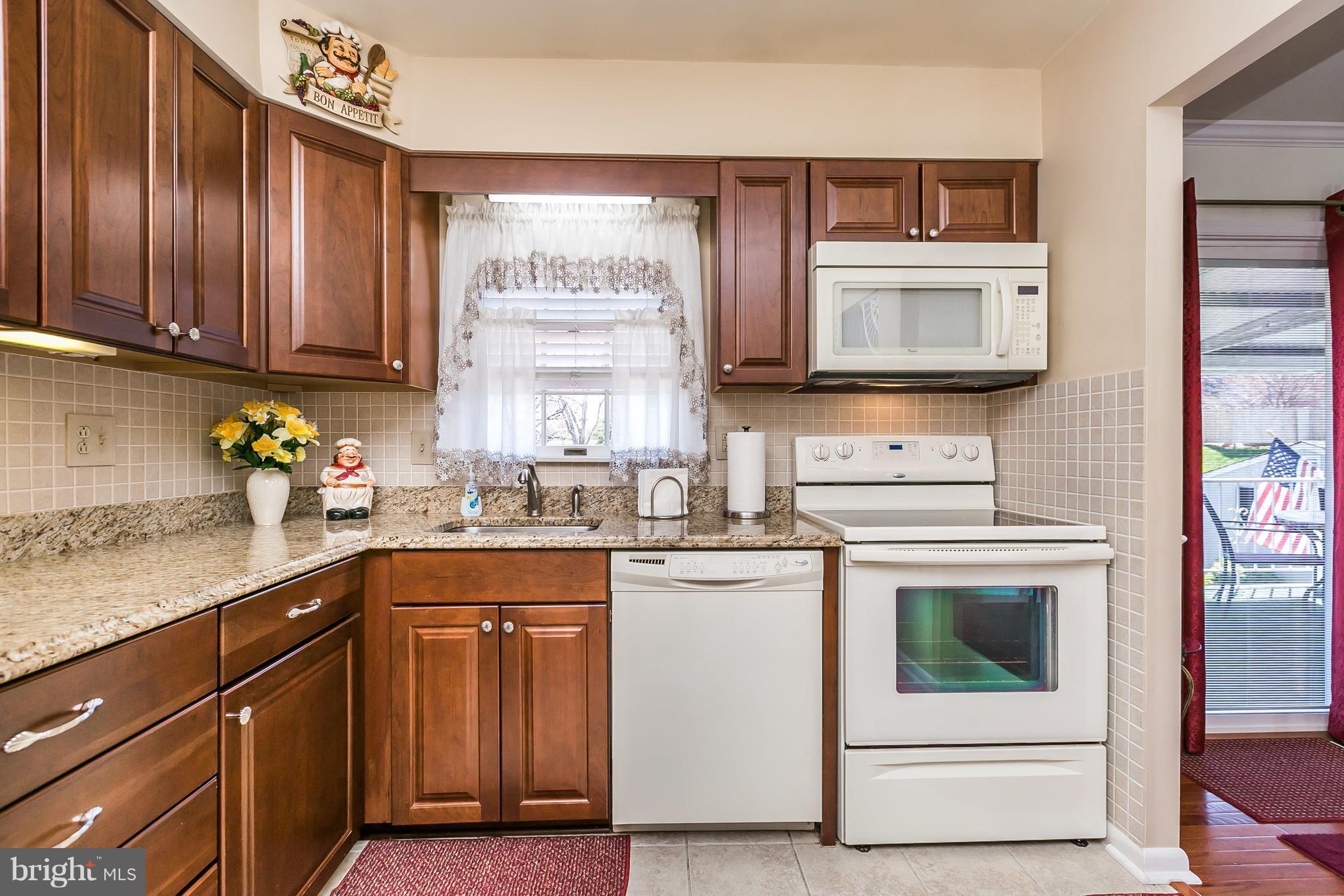 1207 Roxboro Road Baltimore, MD 21237 - Photo 11 of 30 a kitchen with stainless steel appliances granite countertop a stove a sink and a microwave