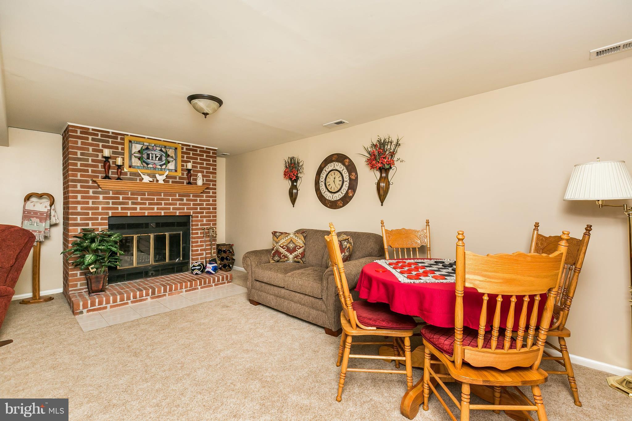 1207 Roxboro Road Baltimore, MD 21237 - Photo 21 of 30 a living room with furniture a floor to ceiling window and a fireplace