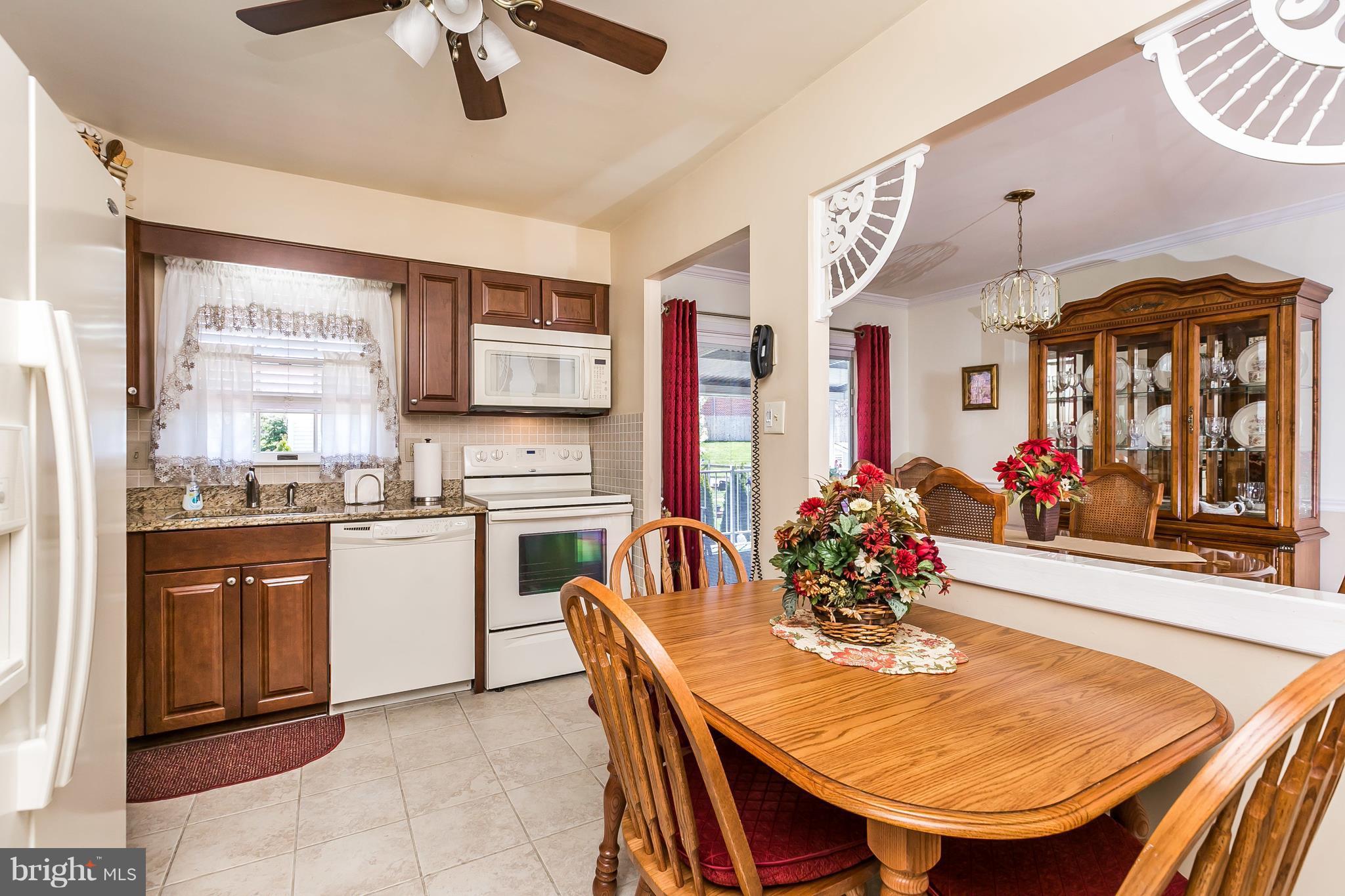 1207 Roxboro Road Baltimore, MD 21237 - Photo 10 of 30 a kitchen with sink refrigerator dining table and chairs