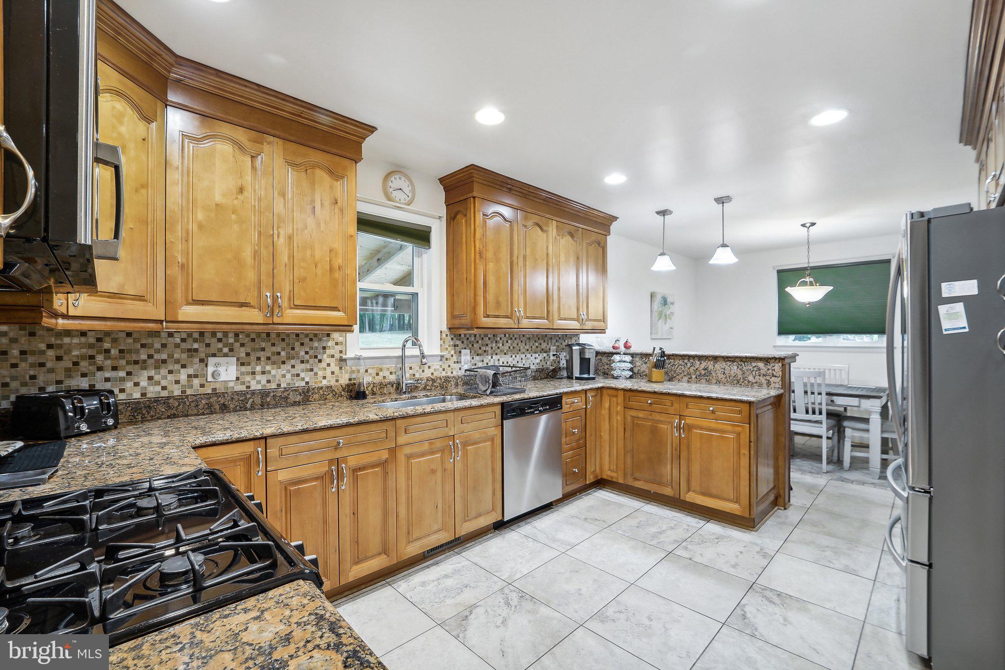 15516 Tierra Drive Silver Spring, MD 20906 - Photo 13 of 62 a large kitchen with stainless steel appliances granite countertop a stove a sink and a microwave