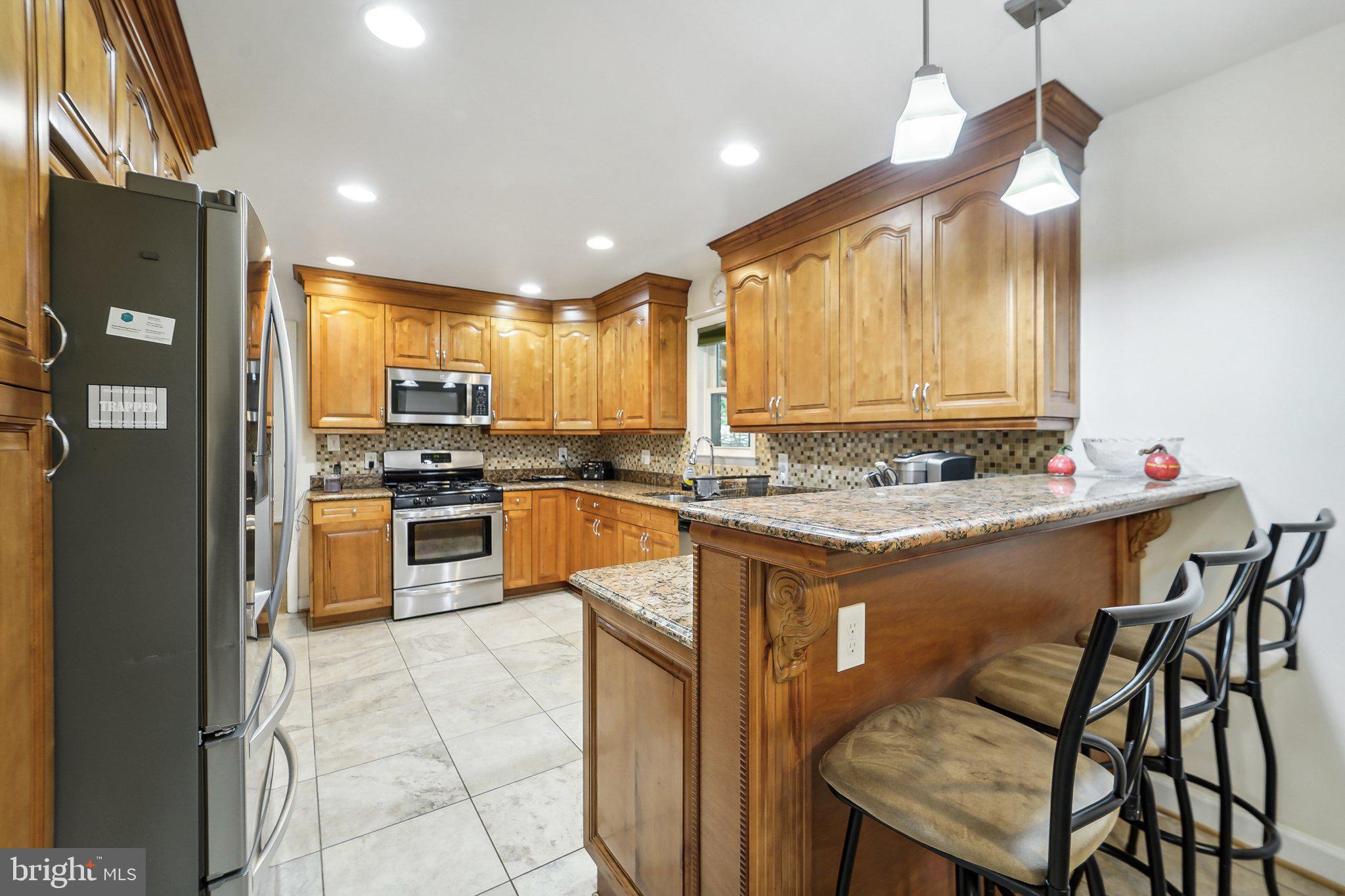 15516 Tierra Drive Silver Spring, MD 20906 - Photo 16 of 62 a kitchen with granite countertop a stove cabinets and refrigerator