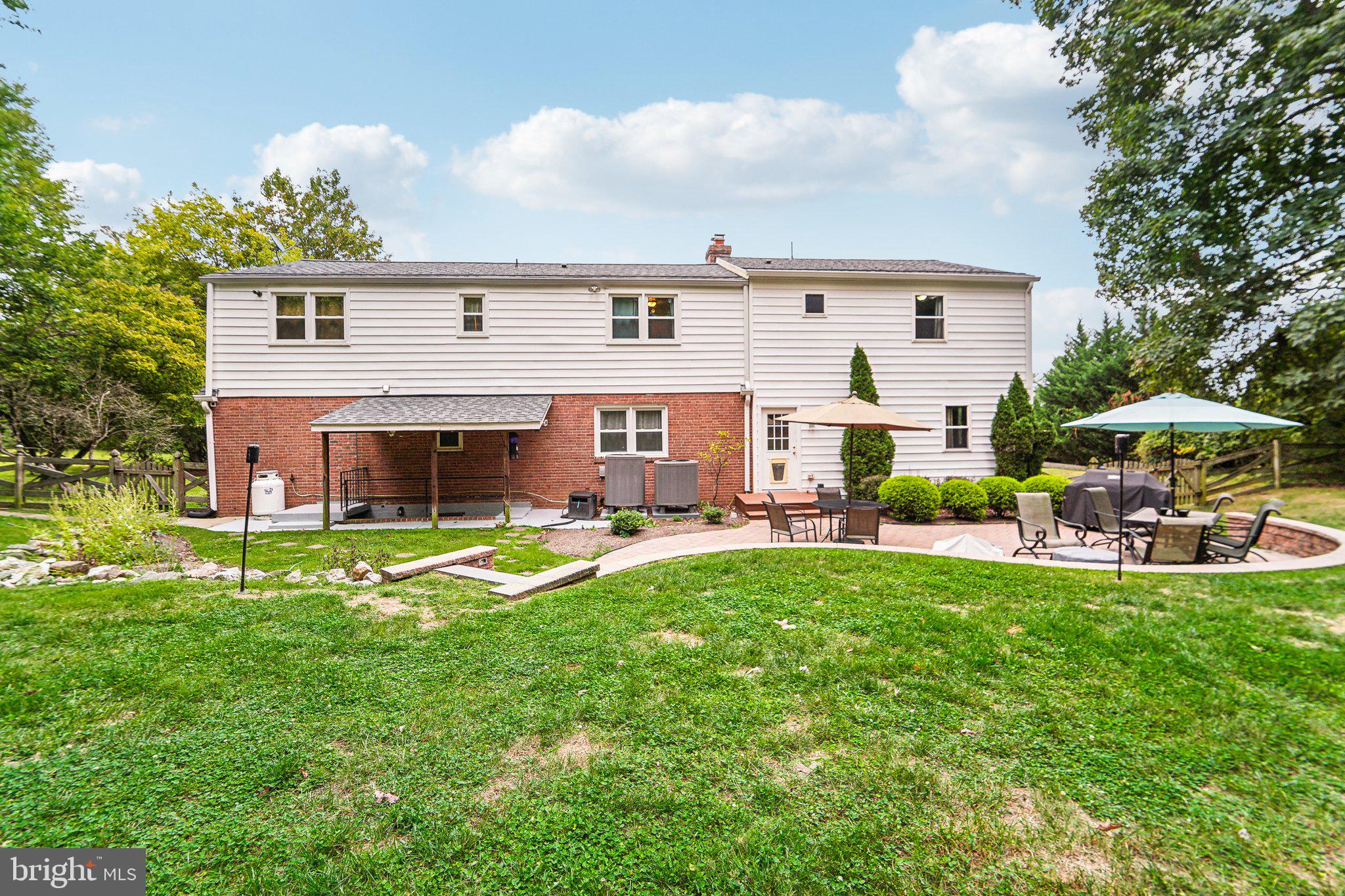 15516 Tierra Drive Silver Spring, MD 20906 - Photo 49 of 62 a view of a house with sitting area and a table and chairs under an umbrella