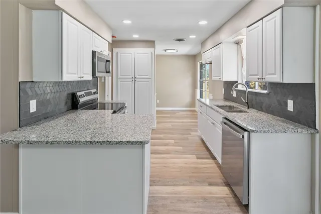 a kitchen with stainless steel appliances granite countertop a sink stove and refrigerator