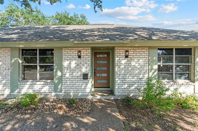 an outdoor view of a house with a large window