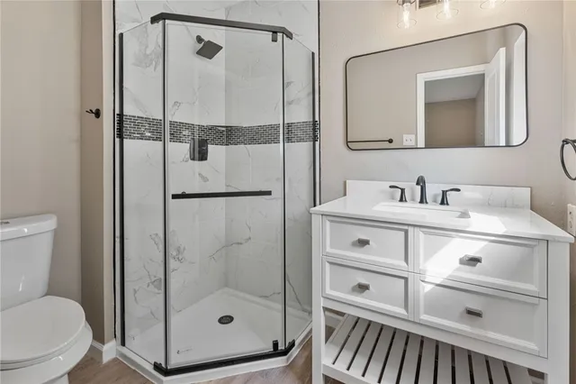 a bathroom with a sink a toilet and shower