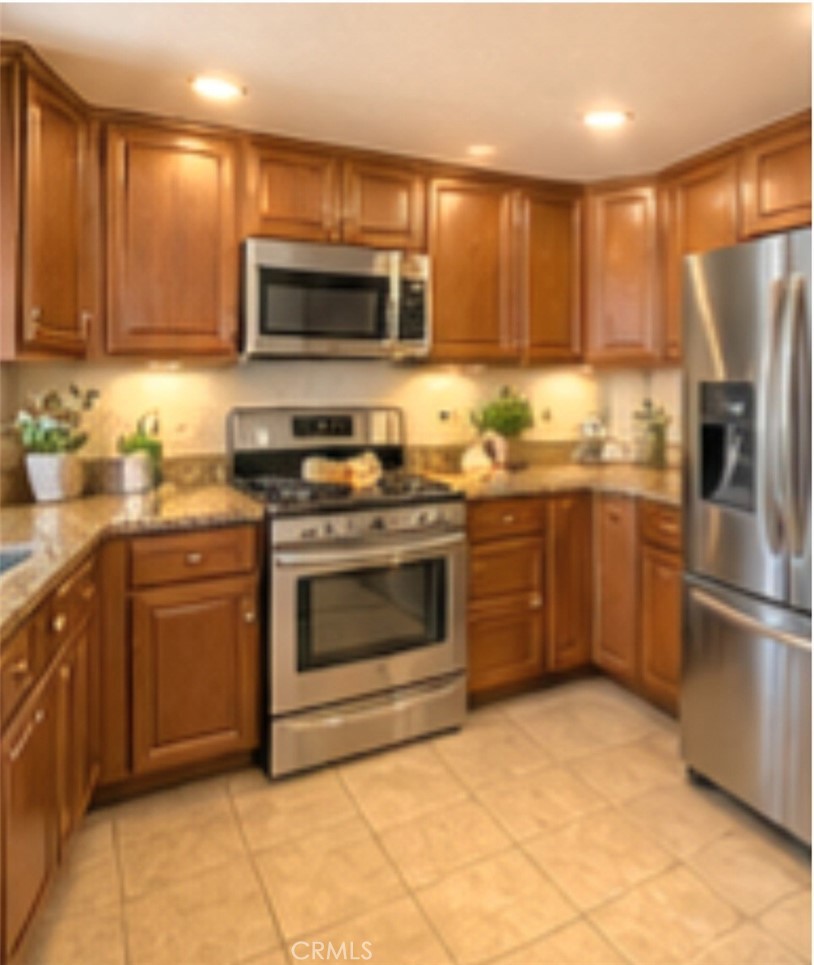 4267 Baggett Drive Riverside, CA 92505 - Photo 3 of 28 a kitchen with stainless steel appliances granite countertop a stove top oven microwave and cabinets