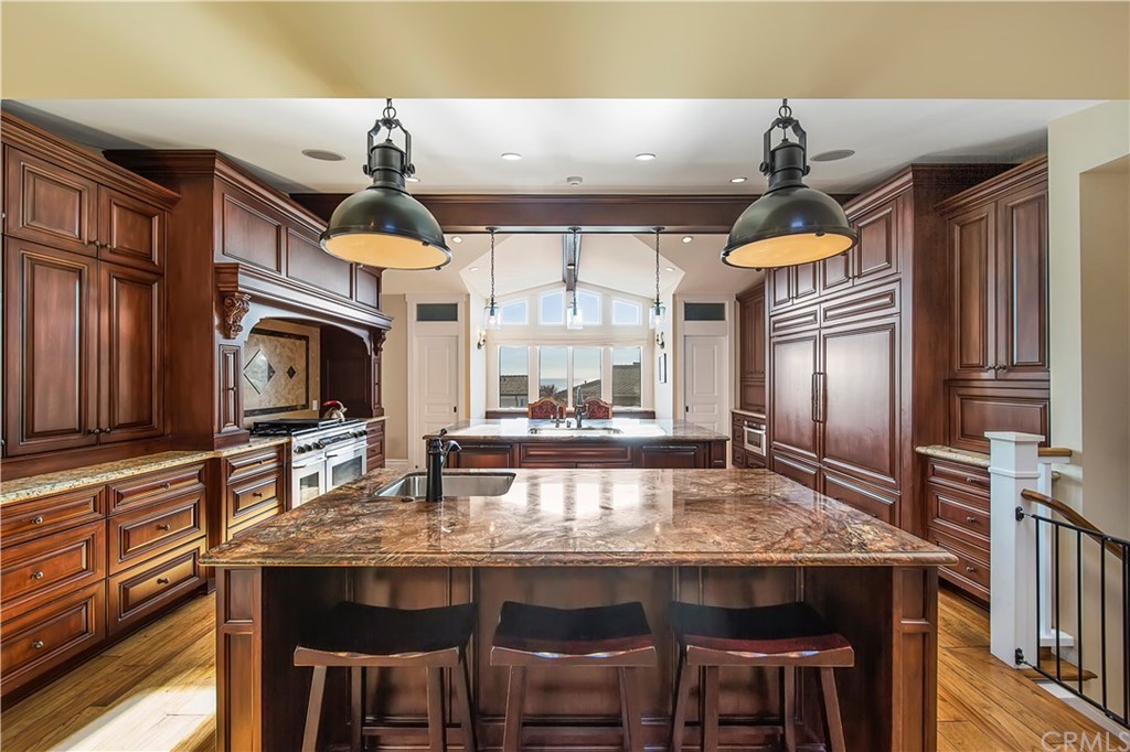 822 Emerald Bay Laguna Beach, CA 92651 - Photo 10 of 25 a kitchen with granite countertop a table chairs stove and cabinets