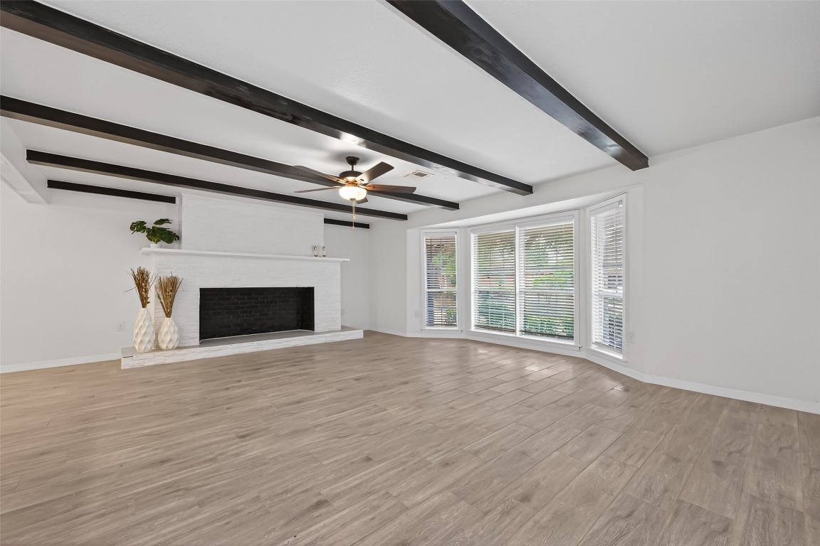 7718 Morley Street Houston, TX 77061 - Photo 13 of 45 an empty room with wooden floor fireplace and windows