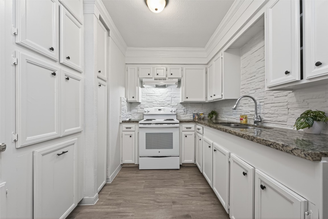 7718 Morley Street Houston, TX 77061 - Photo 22 of 45 a kitchen with granite countertop white cabinets and white appliances