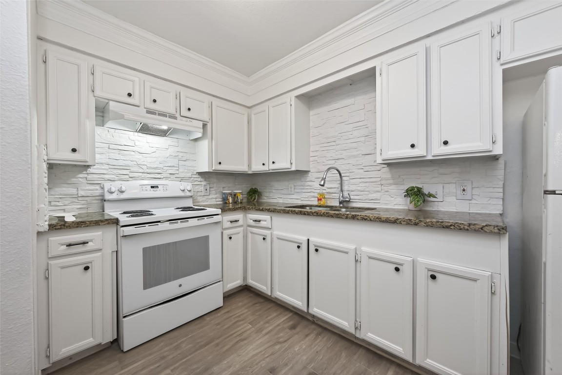 7718 Morley Street Houston, TX 77061 - Photo 23 of 45 a kitchen with granite countertop white cabinets and white appliances