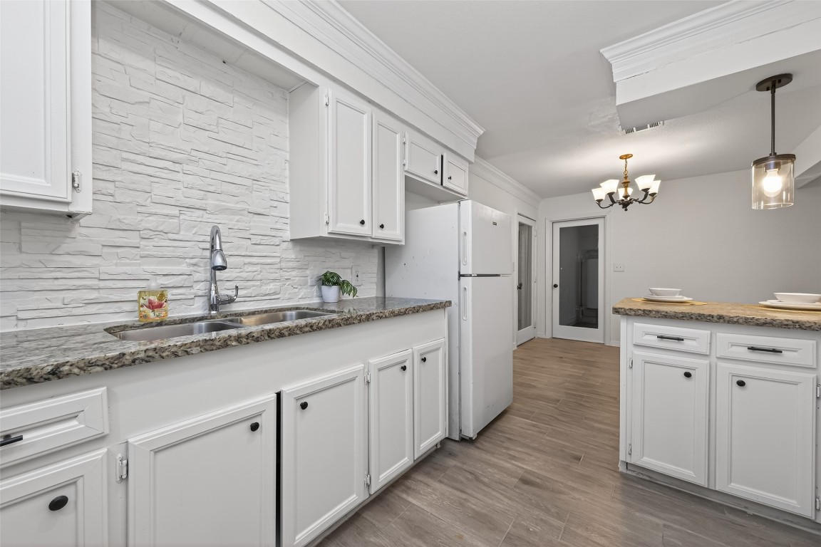 7718 Morley Street Houston, TX 77061 - Photo 24 of 45 a kitchen with granite countertop a sink cabinets and wooden floor