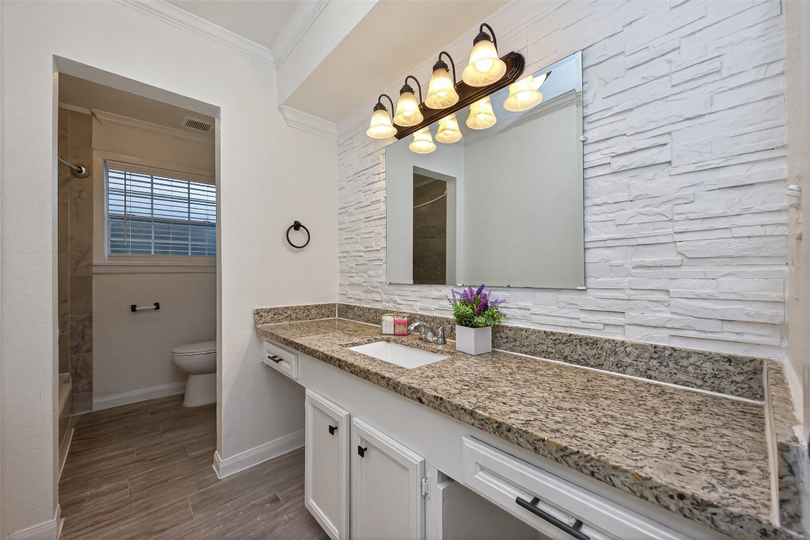 7718 Morley Street Houston, TX 77061 - Photo 40 of 45 a bathroom with a granite countertop sink a toilet and a mirror