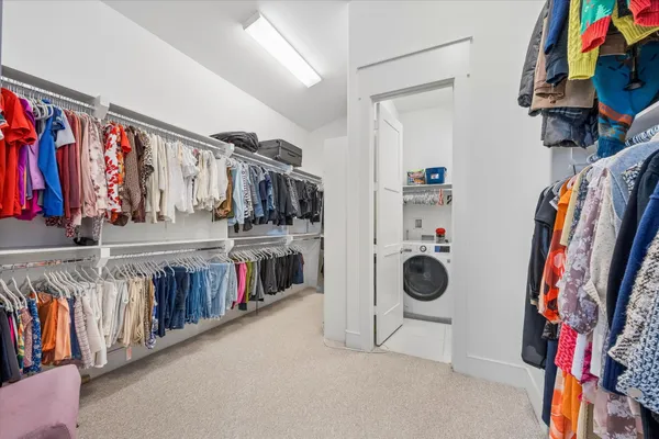 a view of walk in closet with clothes and shoes