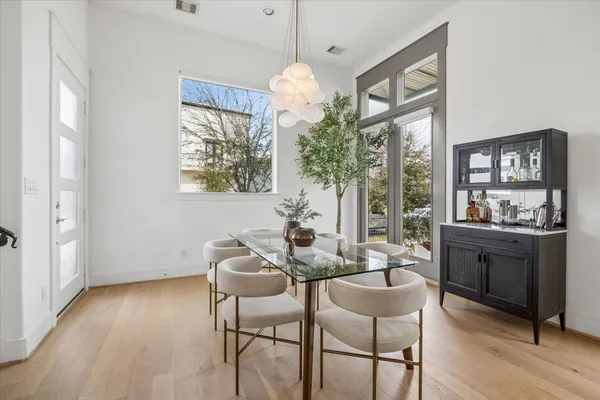 a dining room with furniture a chandelier and wooden floor