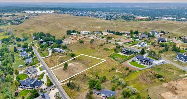 an aerial view of ocean and residential houses with outdoor space