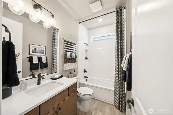 a bathroom with a double vanity sink toilet mirror and shower