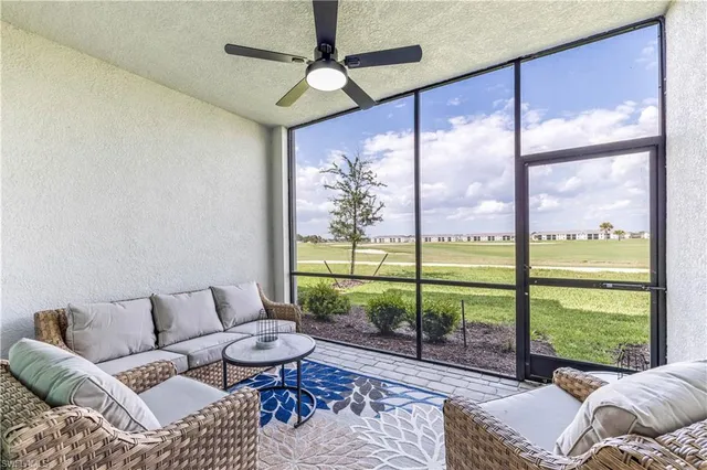 a living room with furniture and a floor to ceiling window