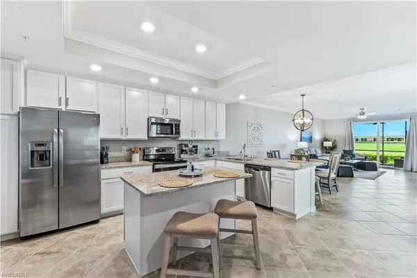 a kitchen with a refrigerator a stove a sink a dining table and chairs