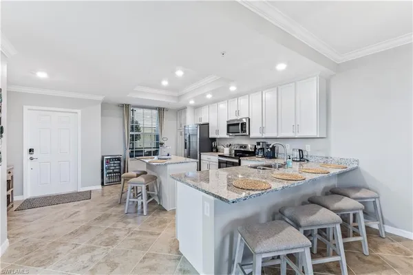 a kitchen with a dining table chairs and refrigerator