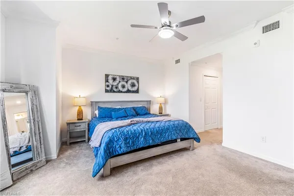 a spacious bedroom with a bed and a chandelier