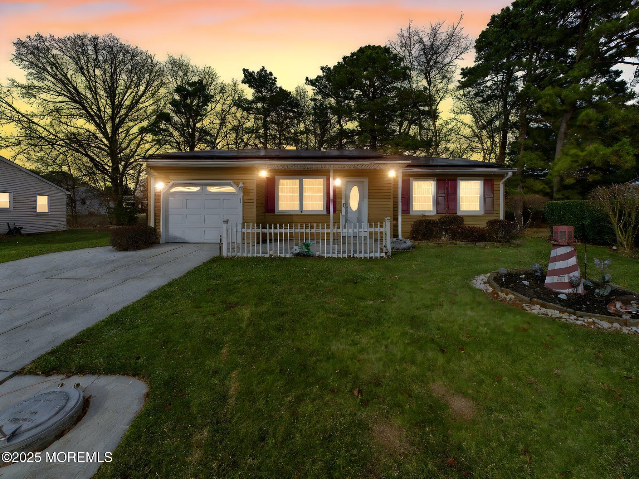 a front view of a house with a yard and trees