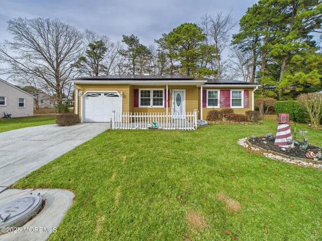 a front view of a house with a yard and trees